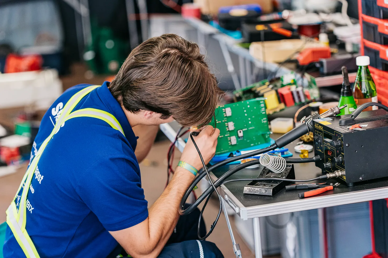 A team member soldering a circuit board in the garage.