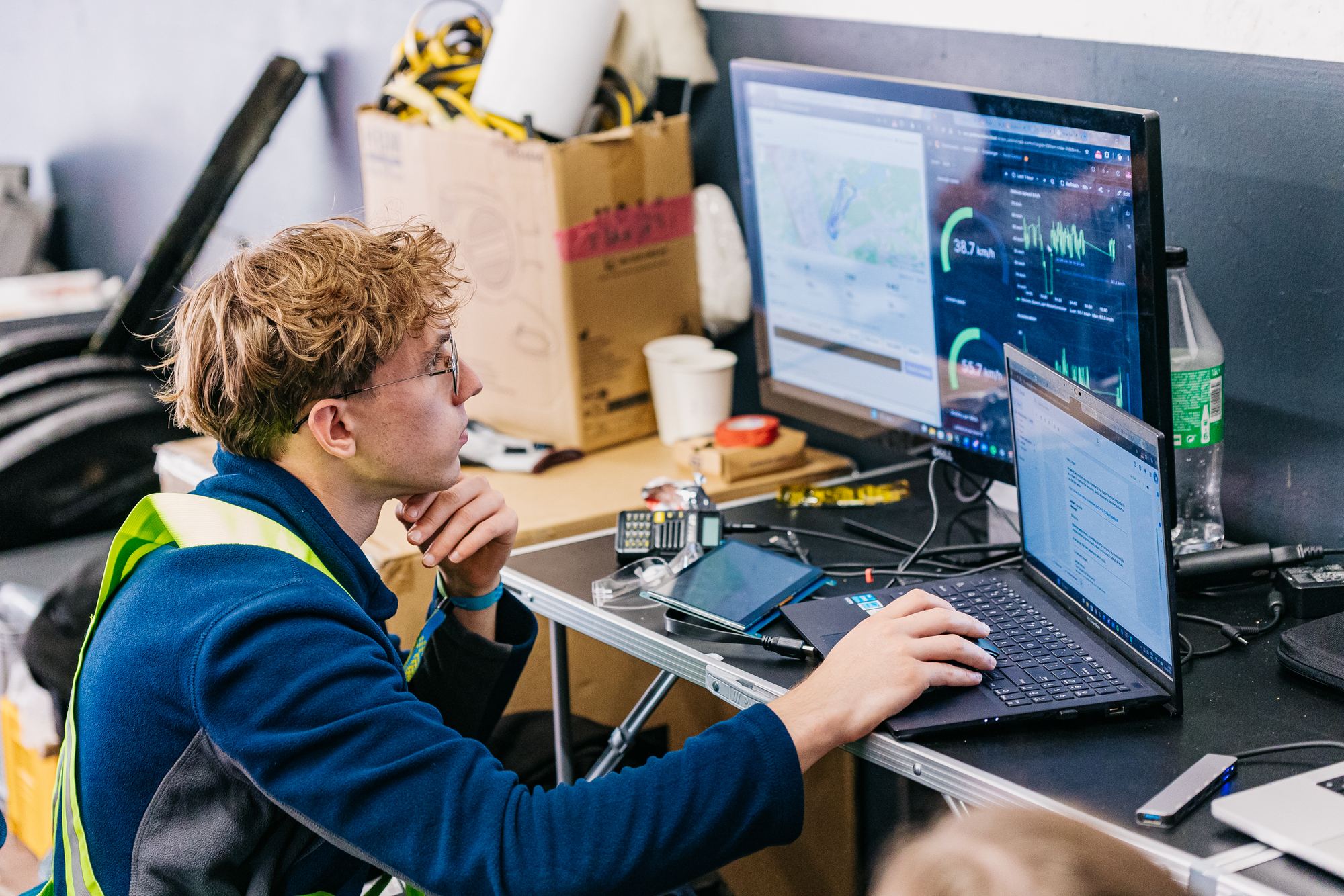 A team member watching the car's telemetry on two screens.